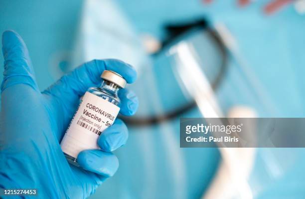 a doctor's hand with a syringe of covid-19 coronavirus vaccine. - coronavirus romania stock pictures, royalty-free photos & images