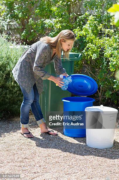 woman throwing water bottles in garbage bin - woman bending over 個照片及圖片檔