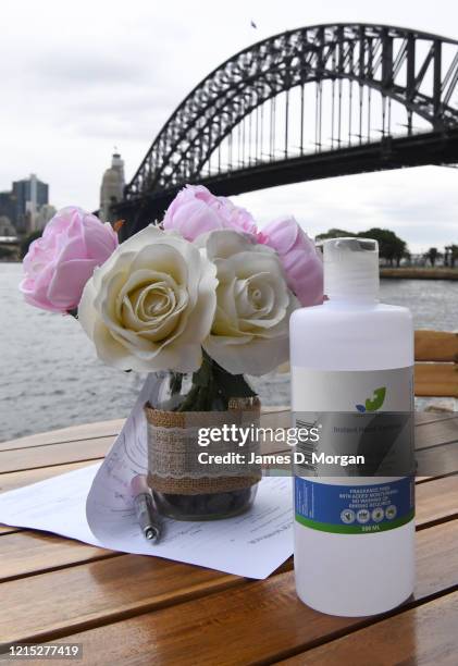 Hospital grade instant hand sanitiser sits next to some flowers as Lara Laas and Daniel Clark are married at Captain Henry Waterhouse Reserve in...