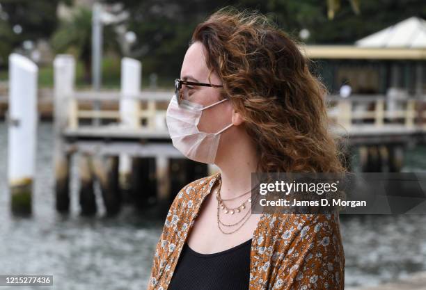 Witness to the wedding of Lara Laas and Daniel Clark wears a face mask during the ceremony as they are married at Captain Henry Waterhouse Reserve in...