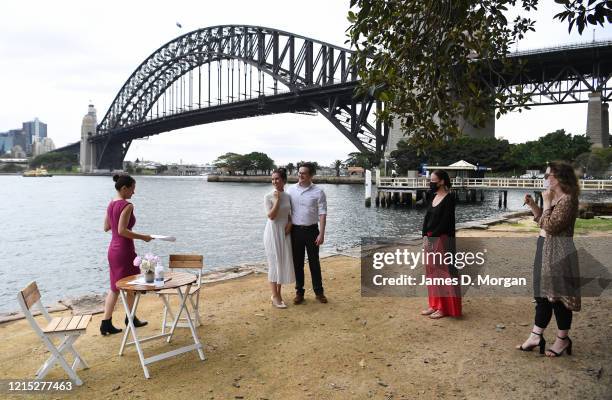 Lara Laas and Daniel Clark as they are married at Captain Henry Waterhouse Reserve in Kirribilli on March 28, 2020 in Sydney, Australia. Weddings are...