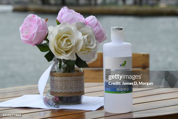 Hospital grade instant hand sanitiser sits next to some flowers as Lara Laas and Daniel Clark are married at Captain Henry Waterhouse Reserve in...