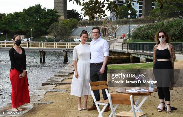 Lara Laas and Daniel Clark pose for a photo with their two witnesses wearing face masks after they are married at Captain Henry Waterhouse Reserve in...
