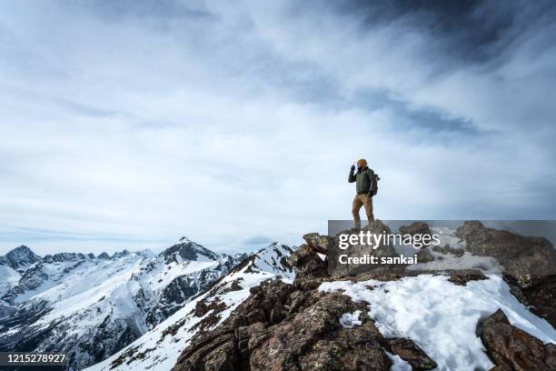 man with walkie-talkie on top of a mountain - walkie talkie stock pictures, royalty-free photos & images