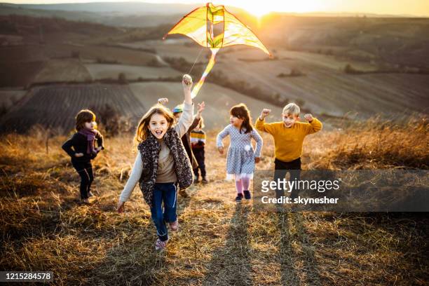 spelen met vlieger in de herfstdag bij zonsondergang! - vlieger stockfoto's en -beelden