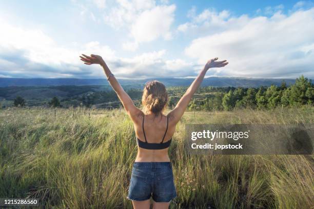 a woman in a mountain valley raising arms in happiness - cordoba argentina fotografías e imágenes de stock