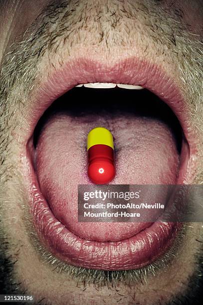 capsule on man's tongue, close-up - mouth with capsule stockfoto's en -beelden