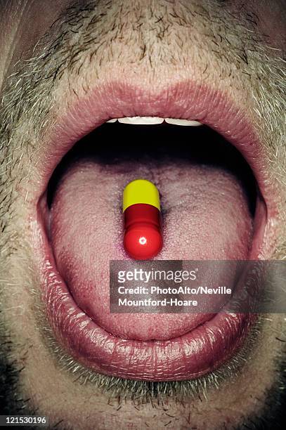 capsule on man's tongue, close-up - man open mouth stock pictures, royalty-free photos & images
