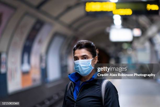 woman wearing a mask on the london subway or tube - máscara-protectora fotografías e imágenes de stock
