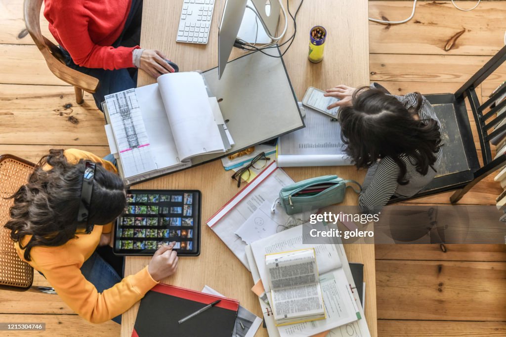 Iedereen doet zijn werk bij houten bureau in woonkamer