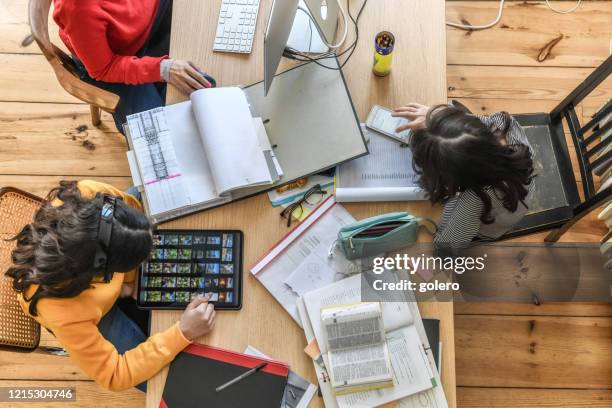 everybody doing his work at wooden desk in living room - homeschooling stock pictures, royalty-free photos & images