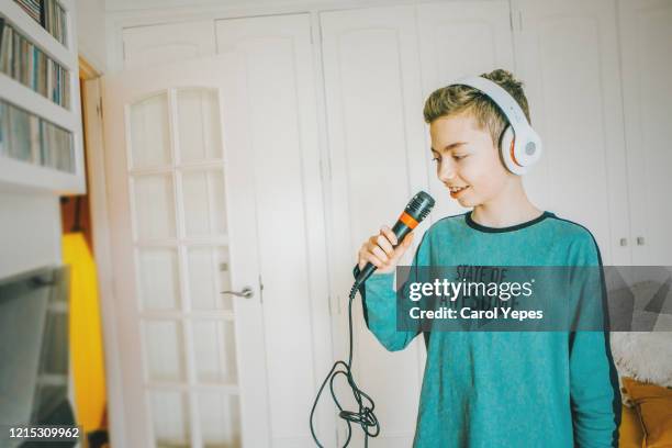 teenager boy singing karaoke at home during lockdown - boy singing stock-fotos und bilder
