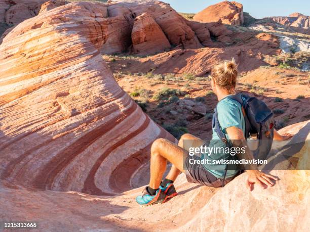 wanderer-mann erwägt roten sandstein - valley of fire staatspark stock-fotos und bilder