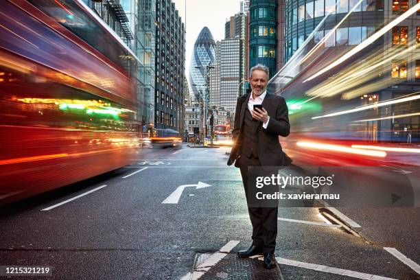 smiling caucasian businessman standing in london street - middle of the road stock pictures, royalty-free photos & images