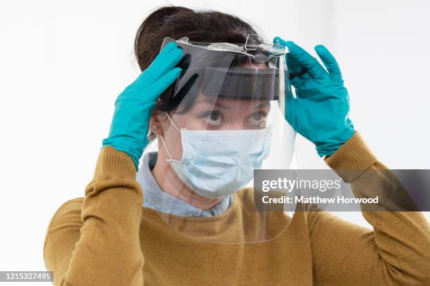 Royal Mint worker Carly O’Donnell wears a medical visor made for NHS workers at the Royal Mint on March 28, 2020 in Llantrisant, Wales. Engineers at...