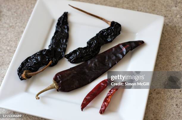 dried mexican chilis on a square white plate - arbol photos et images de collection