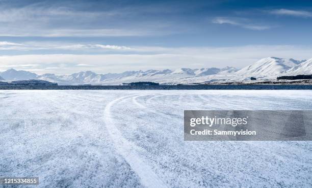 road against snowcapped mountain - snowy road stock-fotos und bilder