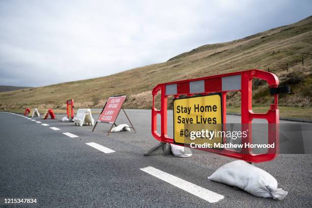 Sign on the A470 near Pen y Fan warns motorists to stay at home to save lives on March 28 in Brecon, Wales. Last weekend the area was busy with...