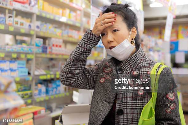 japanese sick woman shopping at pharmacy - panic buying stock pictures, royalty-free photos & images