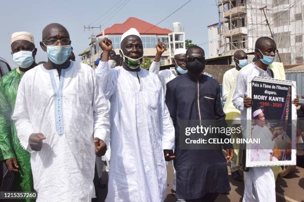 Mourner holds a portrait of the late Guinean singer Mory Kante during his funeral procession on May 26, 2020 in Conakry Guinea. Hundreds of people...