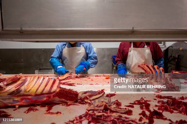 Butchers chop up beef at Jones Meat & Food Services in Rigby, Idaho, May 26, 2020. - As coronavirus clusters in slaughterhouses around the world...