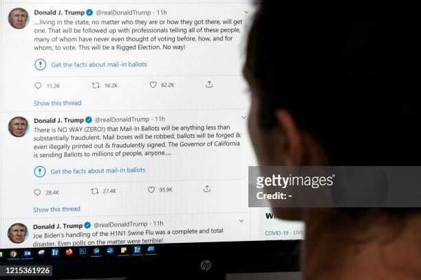 This illustration photo shows an editor in Los Angeles looking at the official Twitter account of US President Donald Trump on May 26 with two tweets...