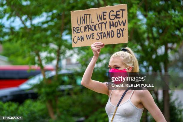 Woman holds a placard while protesting near the area where a Minneapolis Police Department officer allegedly killed George Floyd, on May 26, 2020 in...