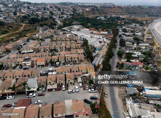 Aerial view of Urbiquinta Marsella housing development and La Nueva Esperanza irregular settlement in Tijuana, Baja California State, Mexico, taken...