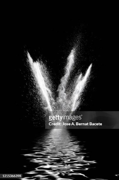 explosion by an impact of a cloud of particles of powder of white color on a black background reflected on the water. - shooting a weapon stock pictures, royalty-free photos & images