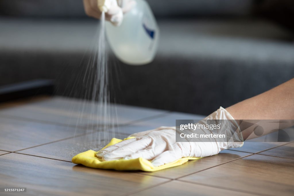 Female hands cleaning desk  with disinfectant wipe.