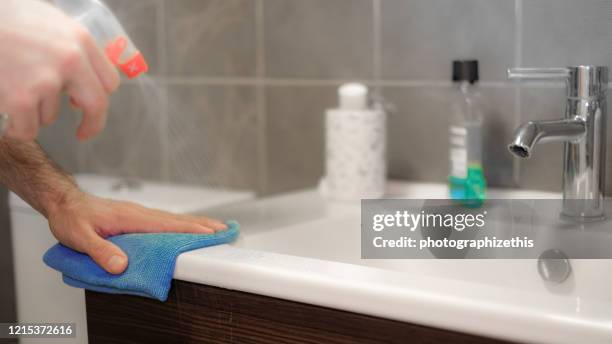 covid-19 wiping down surfaces - spray cleaner stock pictures, royalty-free photos & images