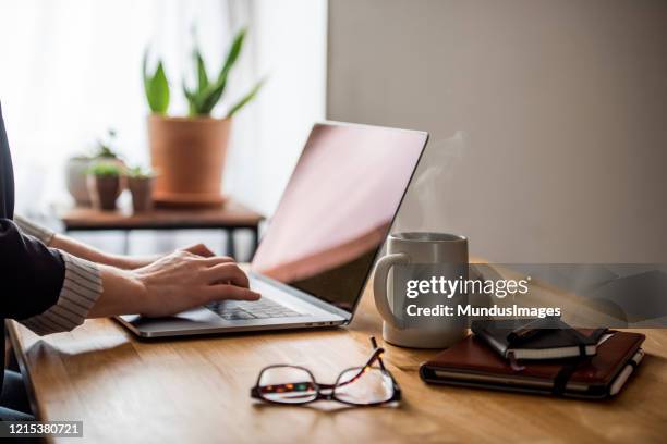 jonge vrouw die van huis werkt - computer work life balance stockfoto's en -beelden