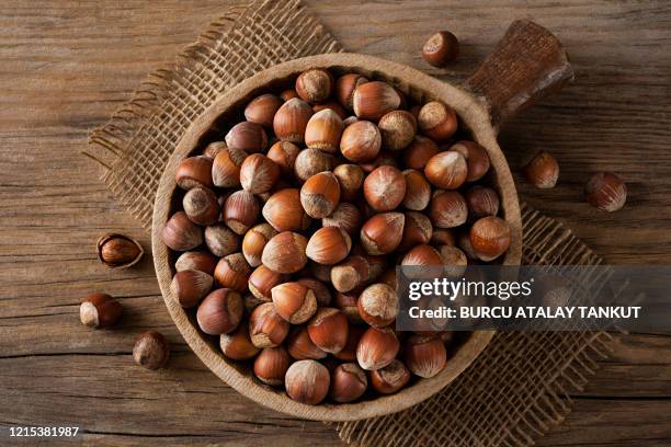 hazelnuts in a wooden bowl - haselnuss stock-fotos und bilder