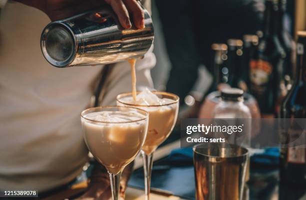 bartender bereitet irish cream likör cocktail mit shaker - likör stock-fotos und bilder