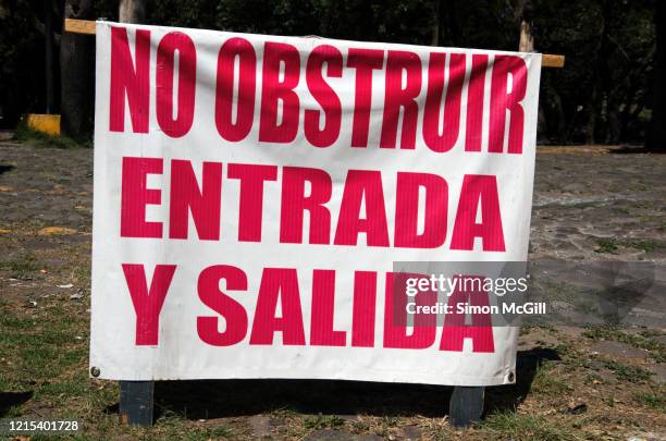 printed canvas sign on a sawhorse in a car park driveway warning in spanish: 'no obstruir entrada y salida' ('do not obstruct entry and exit') - obstruir stock pictures, royalty-free photos & images
