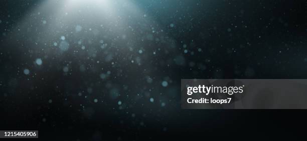 light beam, bokeh and dust - black studio background stock illustrations