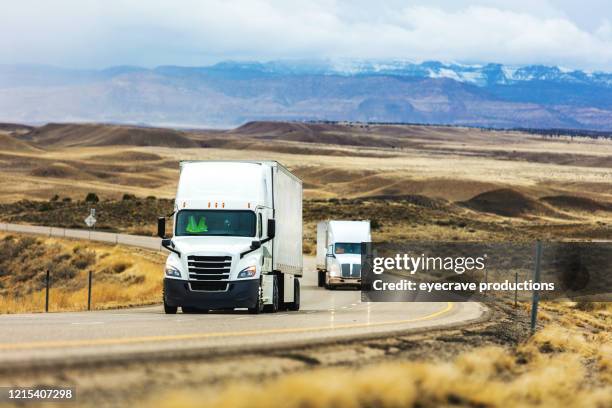 cargo transport long haul semi truck on a rural western usa interstate highway delivering during pandemic - truck front view stock pictures, royalty-free photos & images