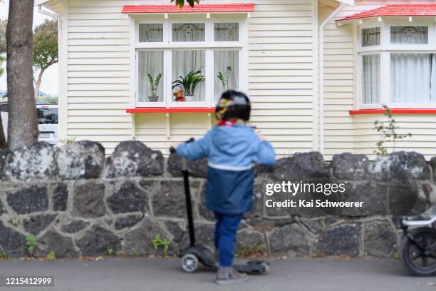 Teddy bear is seen in a window as a boy, who is the photographer's son, passes by on March 29, 2020 in Christchurch, New Zealand. Inspired by the...