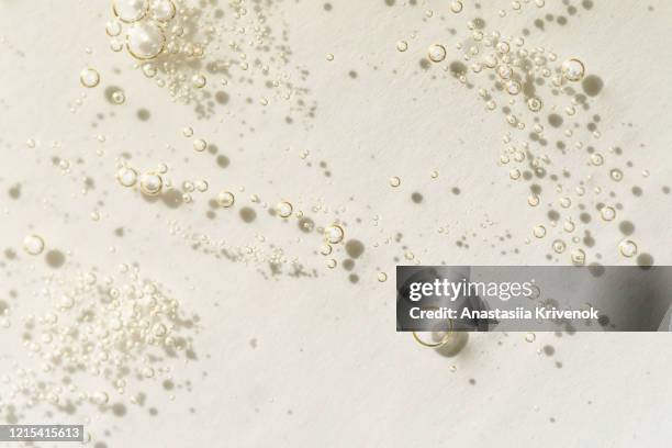 transparent gel cream cosmetic with bubbles on light yellow background. liquid hyaluronic acid gel. top view. - peptídeo imagens e fotografias de stock