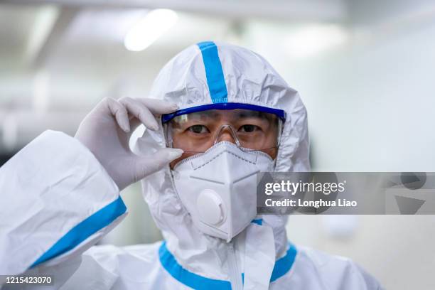 a close-up of a male doctor in a lab wearing a protective suit - ribossomo imagens e fotografias de stock