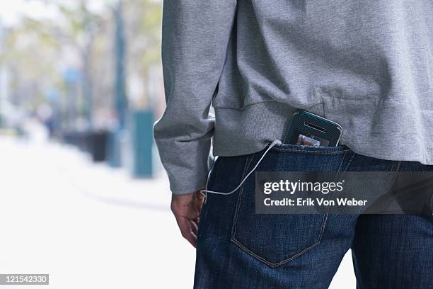 man with mobile music device in his back pocket - jeans poche photos et images de collection