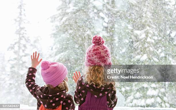 young sisters look at snowfall outside - girls wearing see through clothes fotografías e imágenes de stock