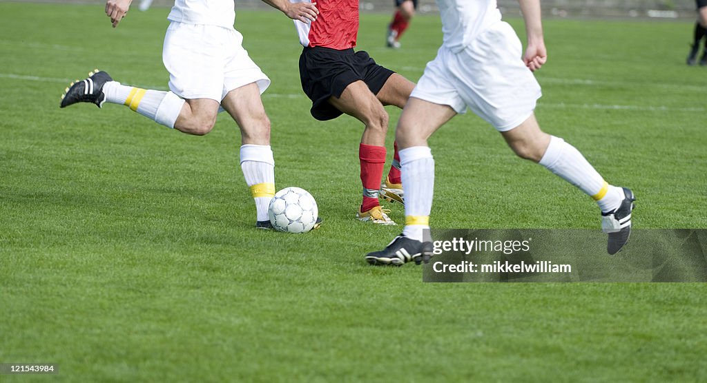 Jugadores de fútbol profesional en el medio de un partido de fútbol