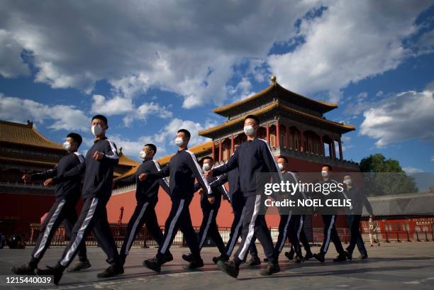 People's Liberation Army soldiers in sports uniform march at the entrance of the Forbidden City on the closing day of the Chinese People's Political...