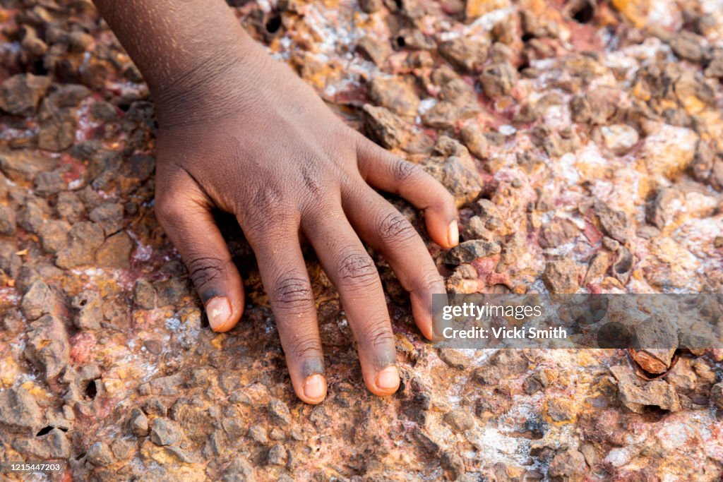 Single hand of a Young Indigenous girl on the rocks