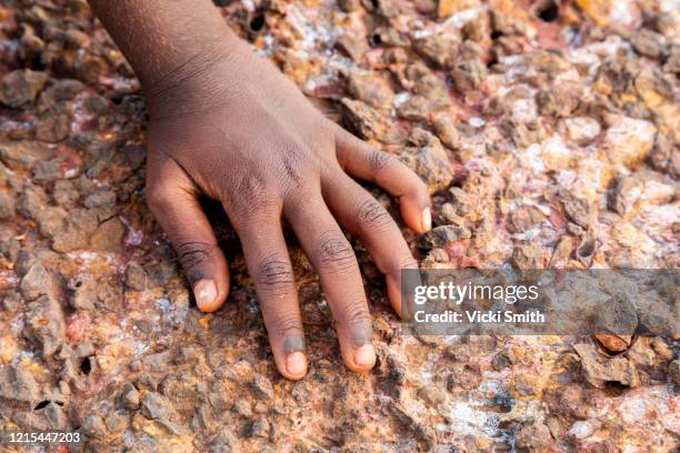 single hand of a young indigenous girl on the rocks - australian aboriginal children stock pictures, royalty-free photos & images