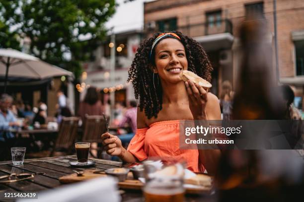 young woman at sidewalk cafe eating - buenos aires food stock pictures, royalty-free photos & images