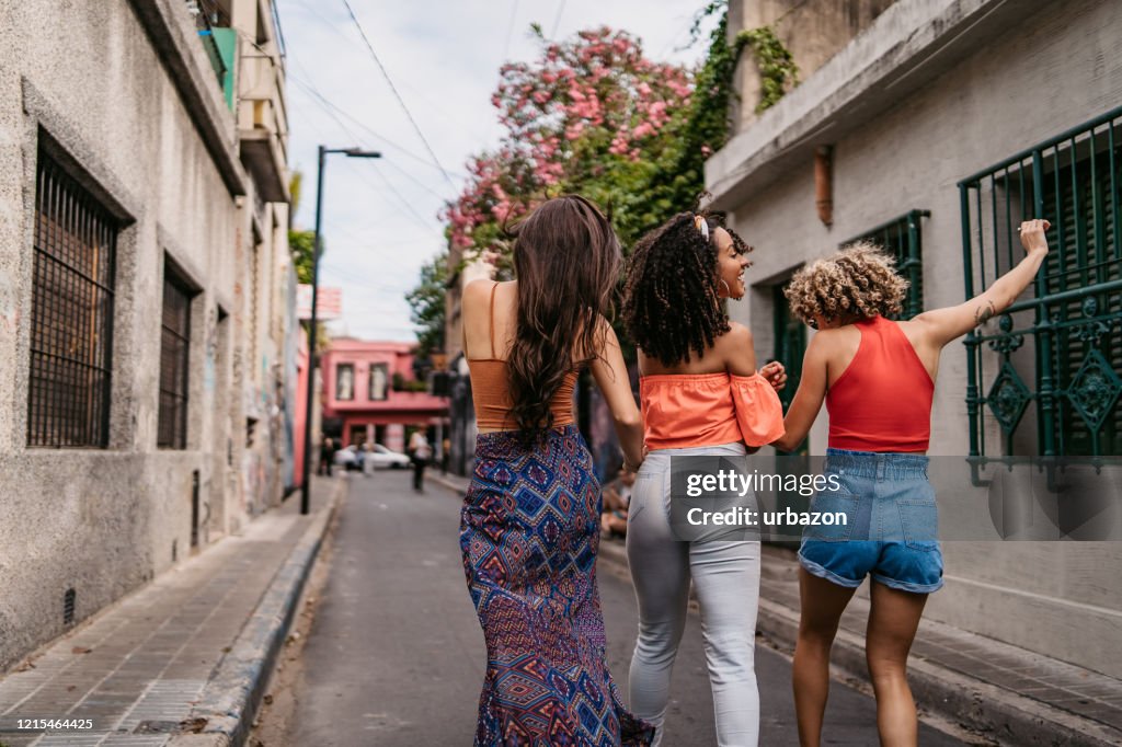 Three young women walking and dancing