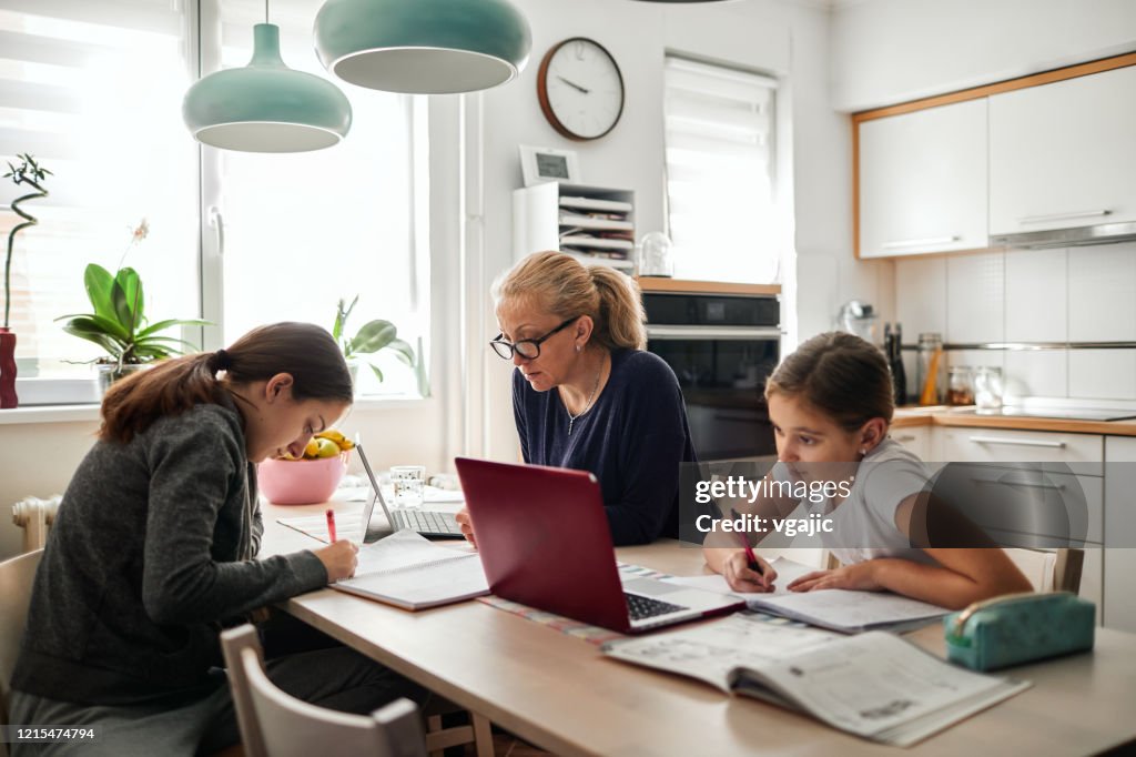 Homeschooling - Mother Helping To Her Daughters To Finish School Homework During Coronavirus Quarantine