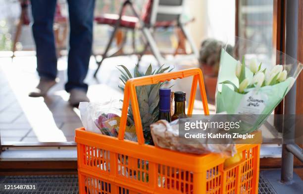 neighborly help: a basket full of groceries left at the door - home delivery 個照片及圖片檔